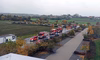 Auf der Zufahrtsstraße zum DELO-Hauptsitz ist eine Reihe von Feuerwehrautos geparkt.
